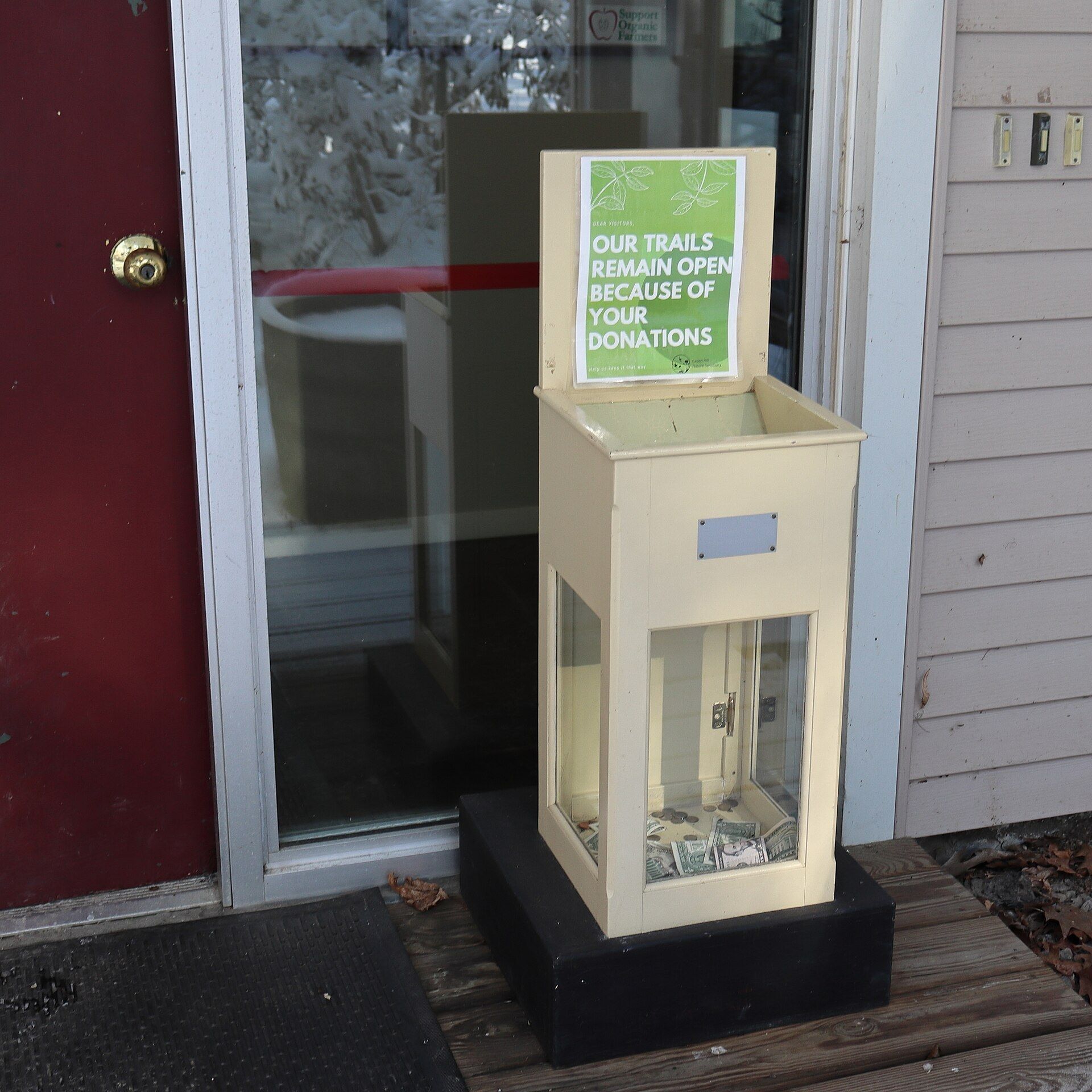 A wooden donation box mounted outside a visitor center. A Wikimedia Commons photograph on Brent O'Mara Insights.