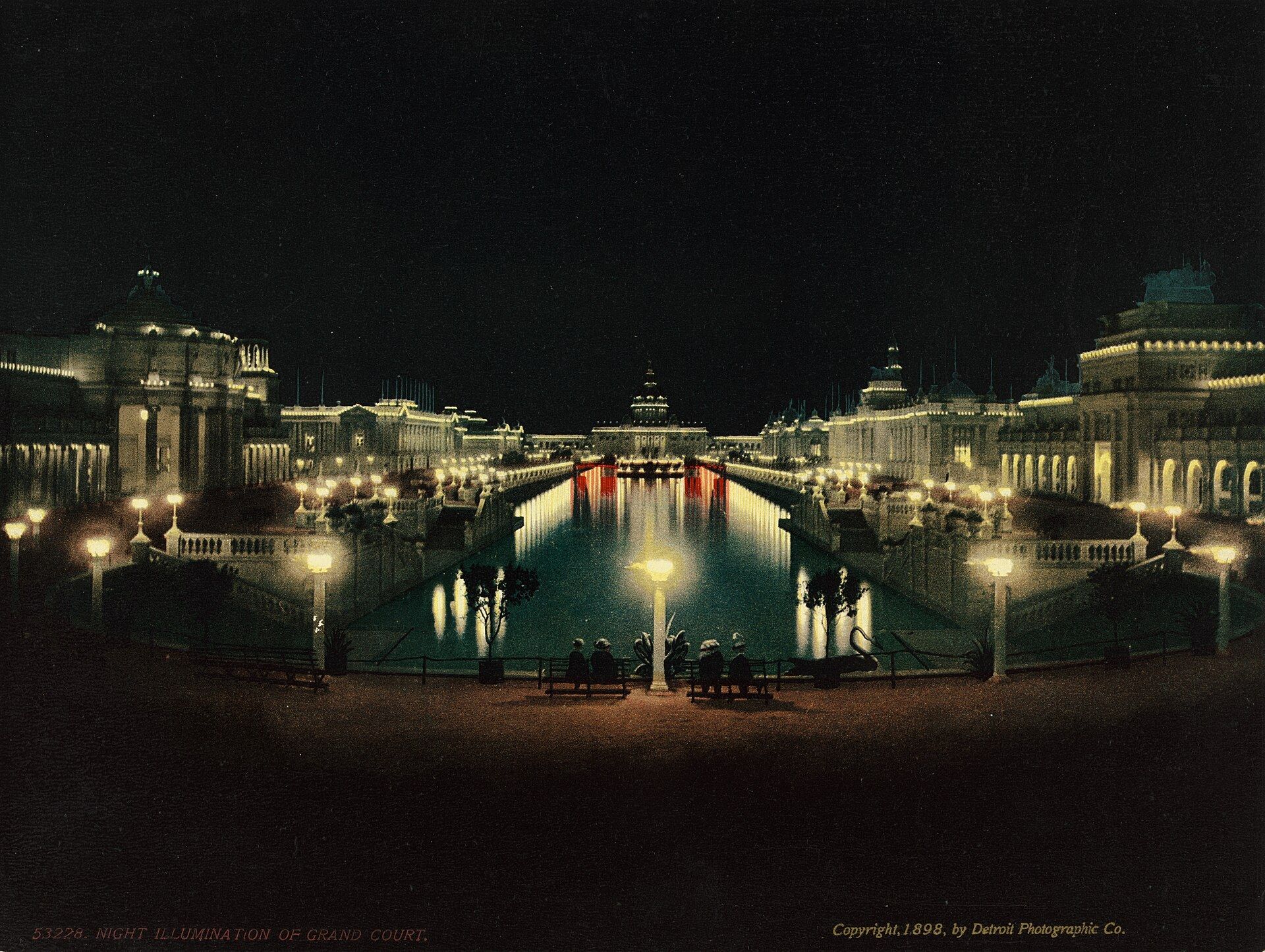The Grand Court of the 1898 exposition in Omaha lit at night with its lagoon and white pav. A Wikimedia Commons photograph on Brent O'Mara Insights.