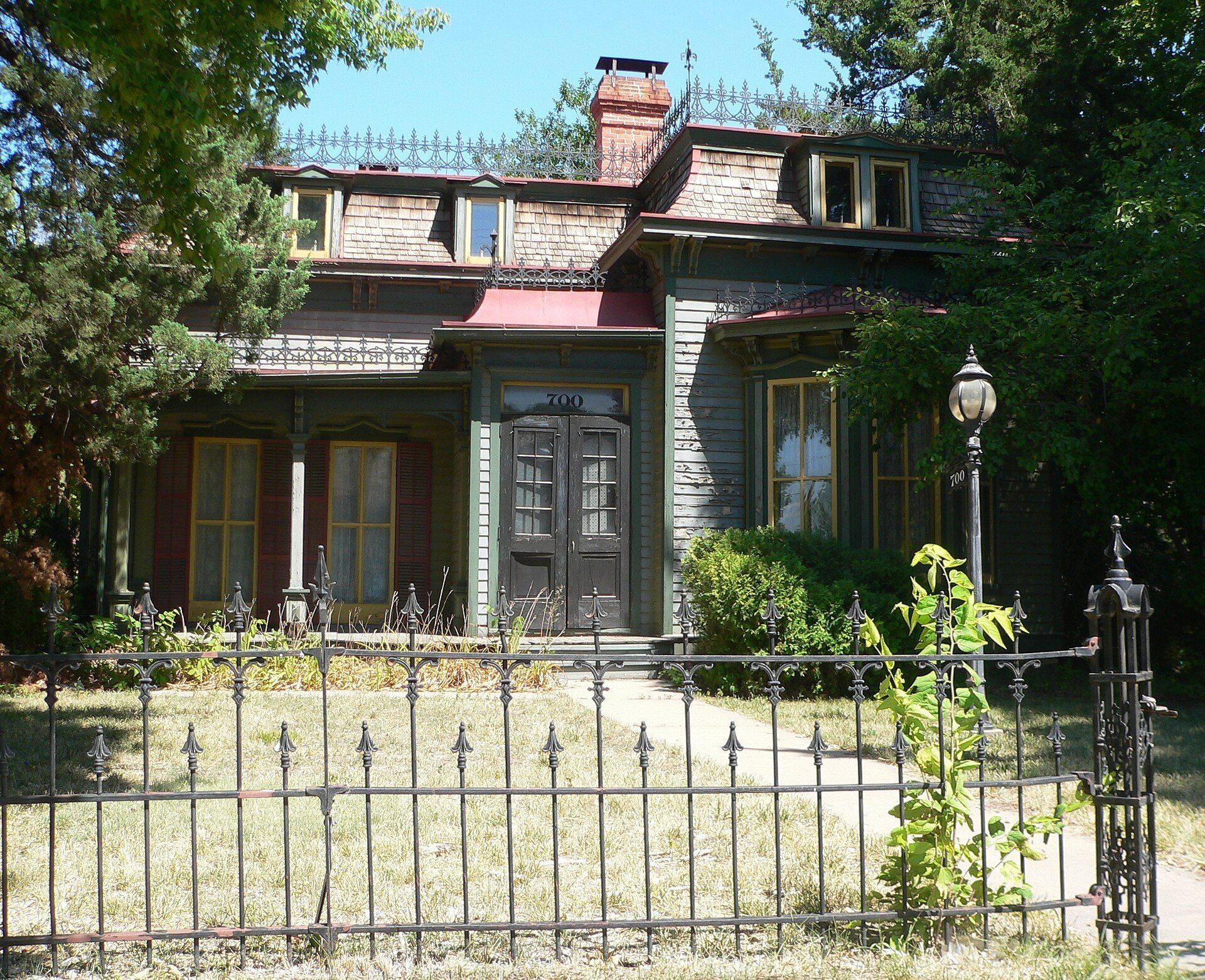 A historic wooden house with a wraparound porch on a street in Lincoln Nebraska. A Wikimedia Commons photograph on Brent O'Mara Insights.